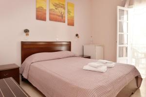 a bedroom with a bed with two towels on it at Hotel Villa Plaza in Spetses