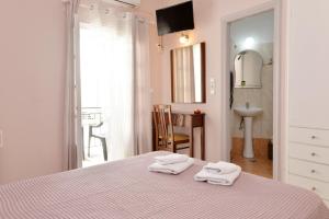 a bedroom with a bed with two towels on it at Hotel Villa Plaza in Spetses