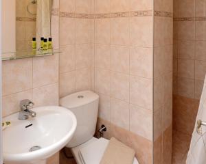 a bathroom with a white toilet and a sink at Hotel Villa Plaza in Spetses