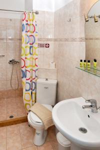 a bathroom with a toilet and a sink at Hotel Villa Plaza in Spetses