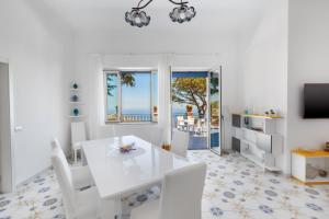 a white dining room with a white table and chairs at Villa Fedora Sea&Stars in Massa Lubrense