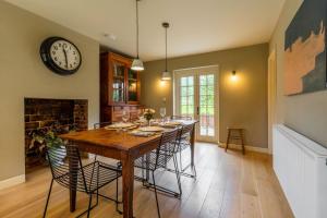 a dining room with a table and a clock on the wall at Host & Stay - Haclins Cottage in Fakenham