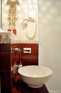 a bathroom with a sink and a phone on the wall at Agorà b&b in Trani