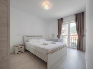 Un dormitorio blanco con una cama grande y una ventana en Family Three bedroom Apartment Brando, en Budva