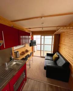 a small living room with a couch and a kitchen at Lake View Lodge Pod in Chichester