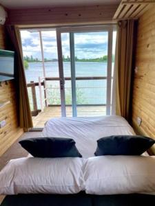 a bedroom with a large bed with a large window at Lake View Lodge Pod in Chichester