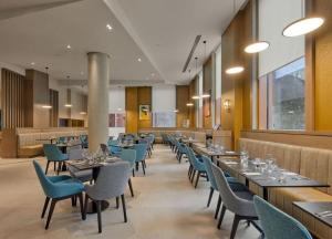 a dining room with tables and chairs in a restaurant at Maldron Hotel Manchester City Centre in Manchester