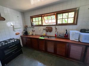 a kitchen with a counter and a sink and a stove at Casa dos Sonhos em Búzios Chez Anna in Búzios