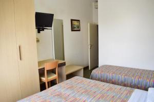 Mały pokój z 2 łóżkami i biurkiem z telewizorem w obiekcie Hotel Gattuccio w Cesenatico