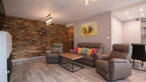a living room with a couch and chairs and a brick wall at Spokojna, Sun & Snow in Wisła