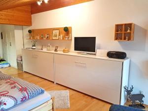 a bedroom with a desk with a television on it at Ferienwohnung Bergblickl in Sachrang