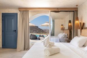 a hotel room with a bed with a large mirror at Panormos Village Hotel in Mykonos