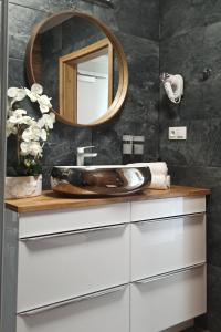 a bathroom with a sink and a mirror at Apartament z basenem i klimatyzacją in Sarbinowo