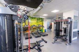 einen Fitnessraum mit Laufbändern und Trainingsgeräten in der Unterkunft Arena Apartments in Havlíčkův Brod