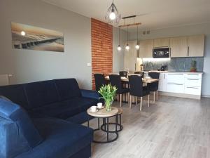salon z kanapą i stołem z krzesłami w obiekcie Apartament z basenem i klimatyzacją w Sarbinowie