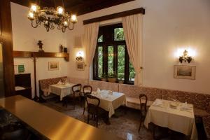 a dining room with two tables and a chandelier at VILA HERBERSTEIN in Velenje +21 photos