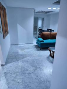 Vacances de charme في سوسة: غرفة معيشة مع أريكة زرقاء وطاولة