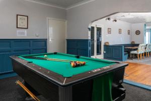 a pool table in a room with blue cabinets at Kenton in Newquay