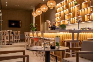 a woman standing at a bar in a restaurant at KoSea Boutique Hotel in Kos