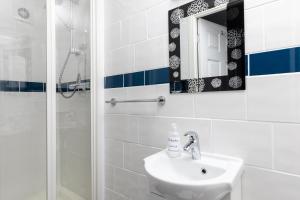 a bathroom with a sink and a mirror and a shower at Kenton in Newquay +23 photos