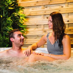 a man and a woman sitting in a bathtub at Le Bras d'or Apparts et Spa in Boulogne-sur-Mer