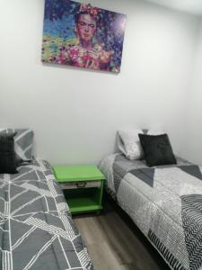 ein Schlafzimmer mit 2 Betten und einem Wandgemälde in der Unterkunft hostal mancora monjitas 755 in Santiago