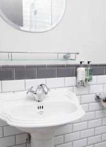 a bathroom with a white sink and a mirror at Rose Revived by Chef & Brewer Collection in Witney