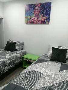サンティアゴにあるhostal mancora monjitas 755のベッド2台が備わる客室で、壁には絵画が飾られています。