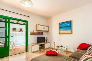 a living room with a couch and a television at Villa Plata by Villa Plus in Puerto del Carmen