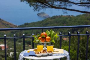 una mesa con naranjas y bebidas en el balcón en Villa Fedora Sea&Stars, en Massa Lubrense