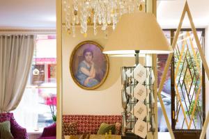 a dining room with a lamp and a painting on the wall at Hôtel du Levant in Paris