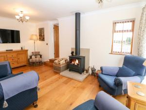 a living room with a fireplace and blue chairs at Brookfield in Matlock