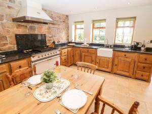 a kitchen with a wooden table and a stove at Brookfield in Matlock