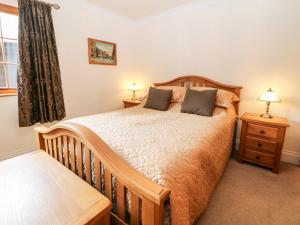 a bedroom with a wooden bed and a window at Brookfield in Matlock