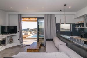 a living room with a couch and a table at Sunset junior suites in Agios Ioannis