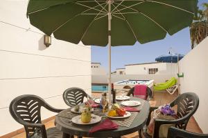stół z zielonym parasolem na patio w obiekcie Villa Tabaiba by Villa Plus w Puerto del Carmen
