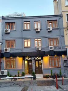 a gray building with a sign that reads permission at CLASS 17 PANSİYON in Çanakkale