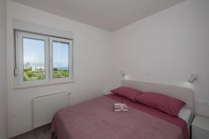 Schlafzimmer mit einem Bett und einem Fenster in der Unterkunft Beach apartment Anđela A2 in Kaštela