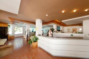 a woman standing at a counter in a store at Hotel Kyrie Isole Tremiti in San Domino