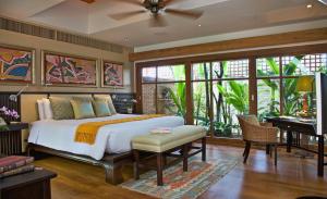 バンラック・ビーチにあるUpni Duniya - Luxury, Beachfront 9-suites Villaのベッドと机と窓のある寝室
