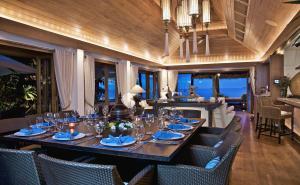 バンラック・ビーチにあるUpni Duniya - Luxury, Beachfront 9-suites Villaの長いテーブルと椅子のあるダイニングルーム