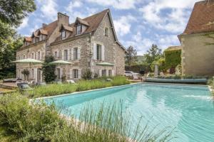 an estate with a swimming pool in front of a building at Manoir du Bois Mignon in Le Fleix