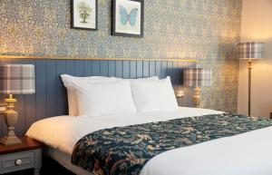 威特尼的住宿－Rose Revived by Chef & Brewer Collection，一间卧室配有一张大床和两盏灯。