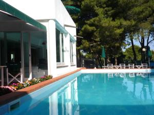 a swimming pool in front of a house at Hotel Kyrie Isole Tremiti in San Domino