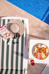um chapéu e uma tigela de comida num banco ao lado de uma piscina em Havuzlu Mustakil Lüx Villa Doğa SAPANCA 150 MT2 em Sapanca