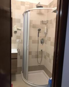 um chuveiro com uma porta de vidro na casa de banho em Albergo Europa em Marina di Mancaversa