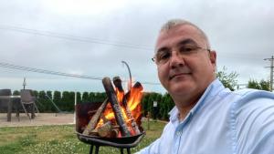 a man is holding a pan of food over a fire at Şahin Tepesi Suite Otel in Trabzon