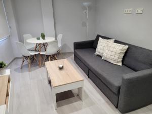 Apartamentos Bluebelle - Marbella في مربلة: غرفة معيشة مع أريكة وطاولة