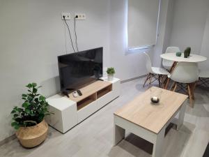 Apartamentos Bluebelle - Marbella في مربلة: غرفة معيشة مع تلفزيون بشاشة مسطحة وطاولة