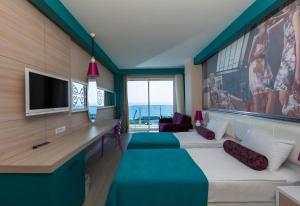 une chambre avec deux lits et un bureau avec une télévision dans l'établissement Sultan of Dreams Hotel & Spa, à Kızılot